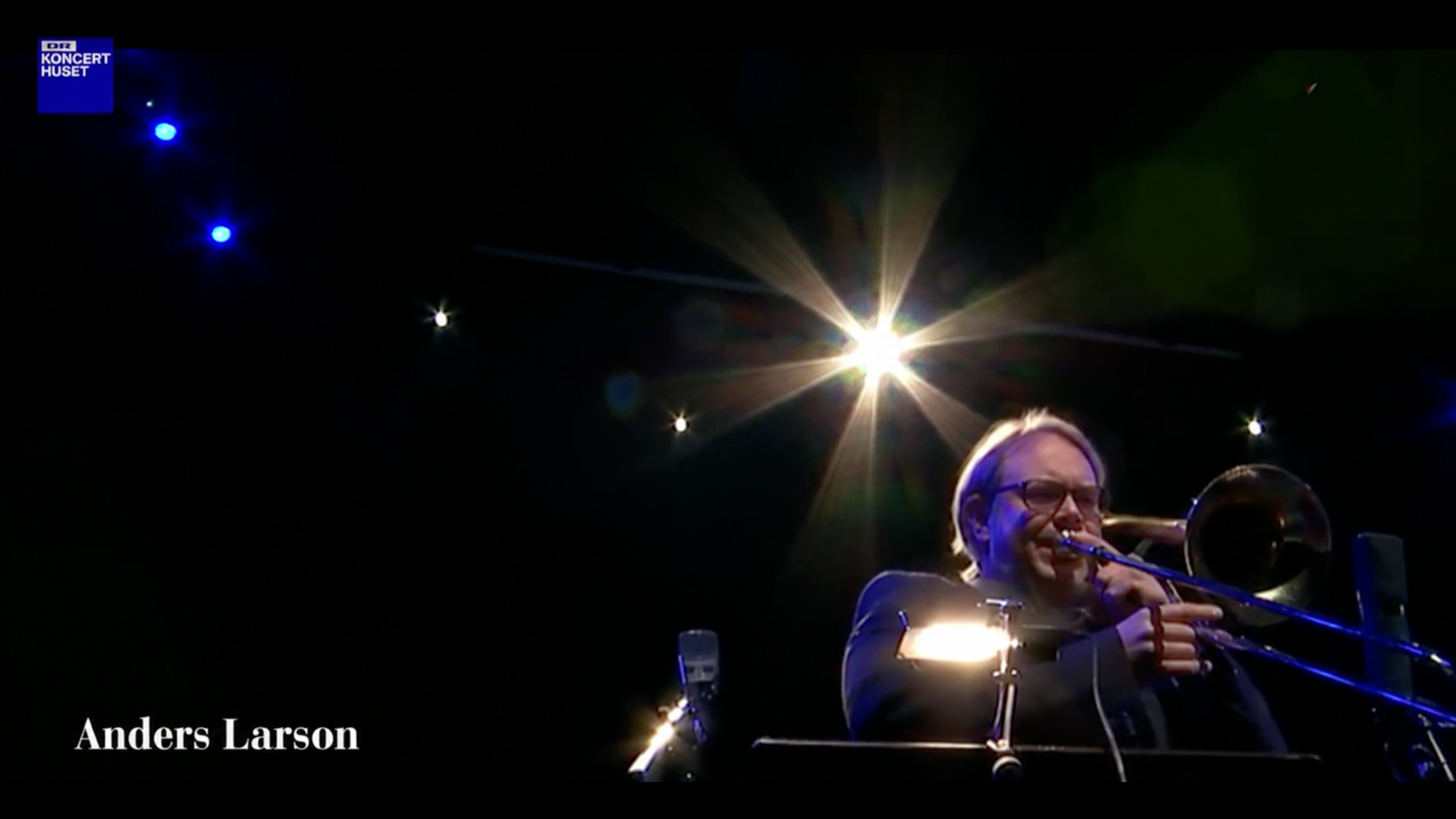 Anders Larson spiller basun i blåt scenelys