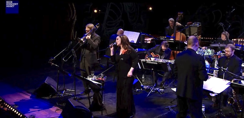Sanger, basunist, dirigent og orkester på scenen